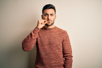 Young handsome man wearing casual sweater standing over isolated white background mouth and lips...