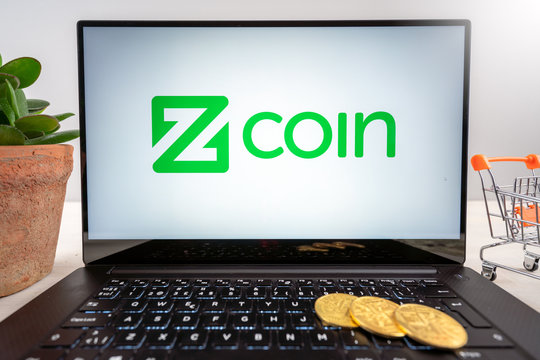 Oslo, Norway - 25.05.2020: Zcoin crypto currency logo on laptop screen together with crypto coins, money tree and shopping trolley.
