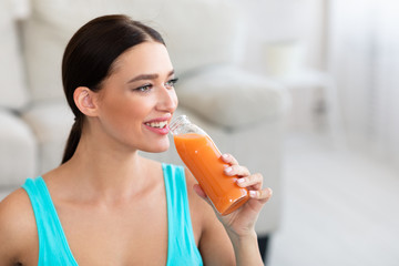 Fototapeta premium Fit Girl Drinking Bottle Of Juice Losing Weight At Home