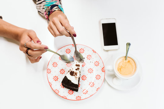 Unrecognizable Two Women Sharing A Piece Of Cake And Enjoying Coffee In A Restaurant Or Bar. Mobile Phone On Table. Human Relationships Concept