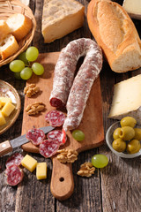 sausage, cheese and bread on wooden board