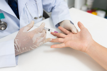 Fototapeta na wymiar Asian doctor or nurse hands with syringe injecting to palm medical. Carpal tunnel syndrome, arthritis, neurological disease concept. Numbness of the hand