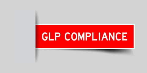 Inserted red color sticker label with word GLP (Good Laboratory Practice) compliance on gray background