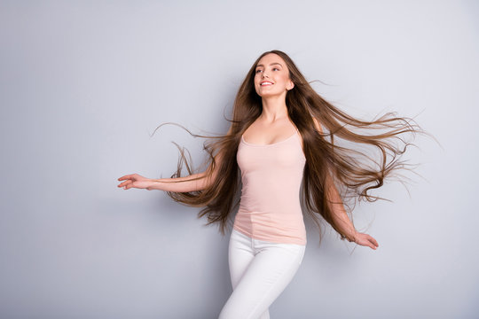 Photo of attractive lady demonstrating ideal neat long healthy hairstyle flying on air after salon walk street graceful wear beige singlet white pants isolated grey color background