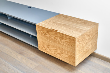 Floating media cabinet in contemporary living room. Wall mounted wooden cabinet