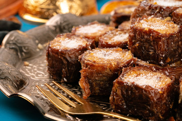 Turkish delight dessert on traditional tableware on dark blue table