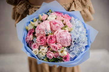 Close-up of pastel-colored bouquet of peonies, roses and hydrangea.