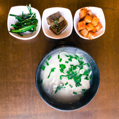 Top view of Ox Bone Soup, milky beef bone soup and several side dishes, Seoul, South Korea. Flat lay