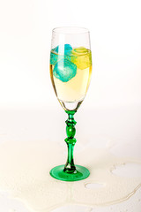 Naklejka premium Beautiful glass with champagne and ice of different colors.
