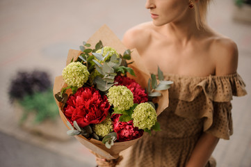 stylish bouquet in hands of young beautiful woman.