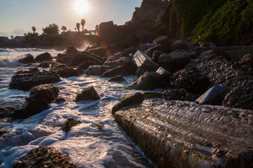 Splashes and waves in the evening light, fragments of ancient ruins