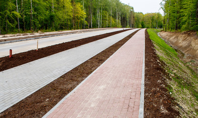 new modern tile sidewalk near a road under construction