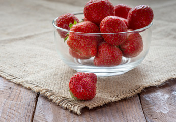 Fresh juicy ripe strawberries in a small Cup on a wooden table.