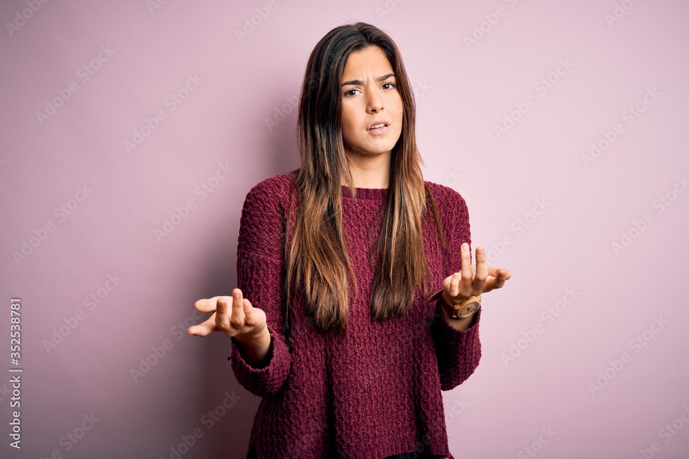 Sticker young beautiful girl wearing casual sweater over isolated pink background clueless and confused with