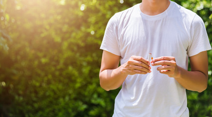 May 31 of World No Tobacco Day, Asian smoker man use hands breaking down cigarettes on green leaves...