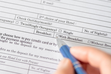 Woman filling hotel reservation form check mark choosing breakfast in hotel service. Reception...