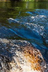 a small forest waterfall quickly runs over stones