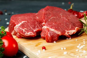 Slice of raw beef fillet on wooden board