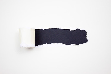Torn white paper with jagged edges horizontally on a black background for your text.