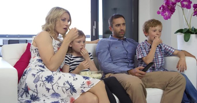 4K Medium Shot Of Family Cheering While Watching Sports Game On TV
