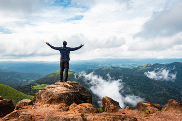 man isolated watching the serene nature at hill top with amazing cloud layers in background