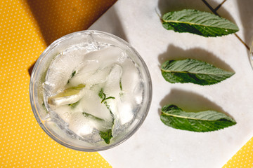 Close up details of mojito alocholic drink on yellow background