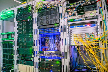 Several racks with telecommunication equipment are in the data center server room. The central technical platform of the Internet provider. Concept of computerized information technology.