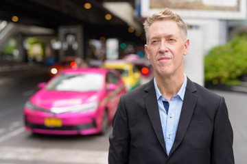 Mature businessman in suit waiting at the taxi station