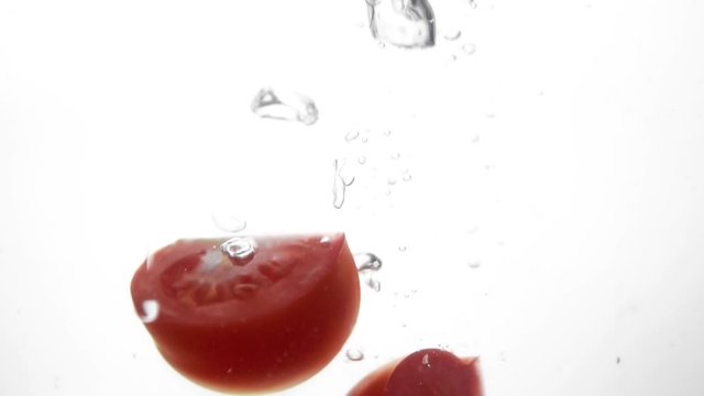 Photo of fresh sliced tomato dropped in water