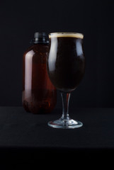 This bowl is made of crystal. The beer is a Dry Stout with grape must Tannat, Cabernet Franc, and Petit Verdot. Photo produced in low light, black background, lower exposure.