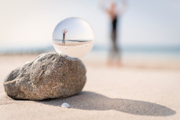 Yoga am  Ostsee Strand , fotografiert durch eine Glaskugel