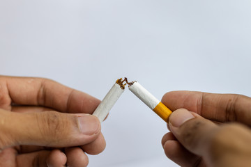 Male hand crushing cigarette on white background, Concept Quitting smoking, World No Tobacco Day