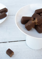 Chocolate candies on a plate on white background.