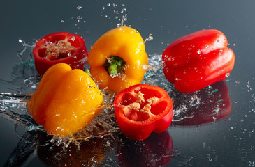 Red and yellow paprika in water splashes.