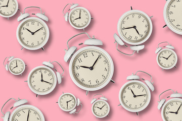 Many alarm clocks on pink background