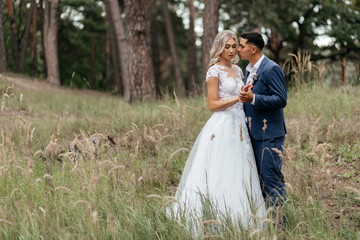 Groom looking at the bride while they are standing close to each other in the park