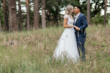 Bride kissing groom who is holding her hand
