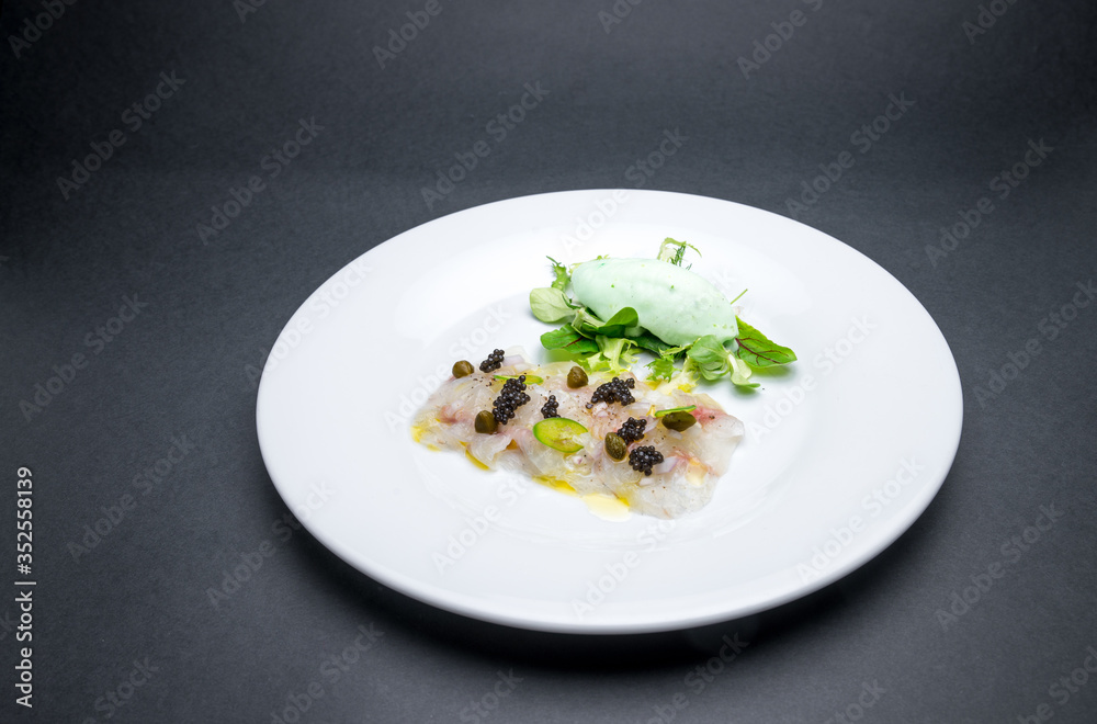 Wall mural fresh fish carpaccio with black sturgeon caviar