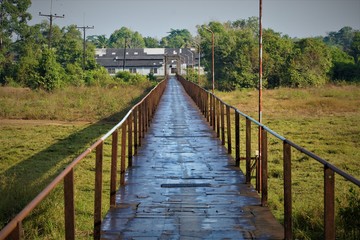 Obraz premium Old Metal bridge across green field