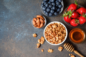 Homemade oatmeal granola bowl with berries on dark background