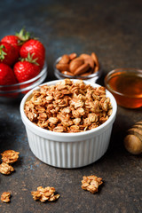 Homemade oatmeal granola bowl with berries on dark background.
