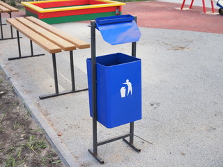 Concept of keep tidy shown by litter bin trash can in children's playground.