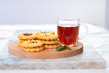 Tasty hot black tea. Homemade fresh cookies and a cup of tea on marble table on white light grey background.