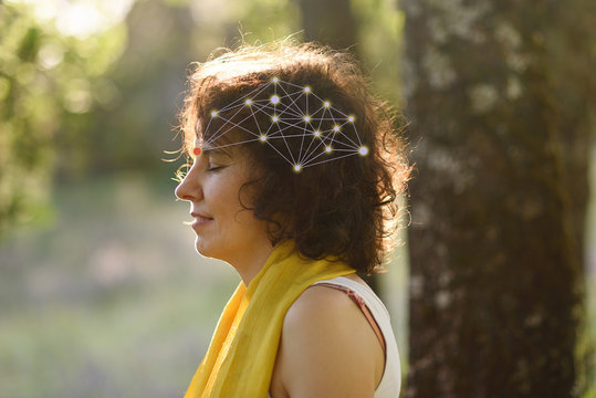 Young woman meditating outdoors with neural diagram. Concept of digital disconnection and connection with oneself and nature.