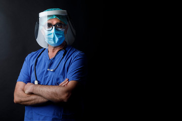 Medico  con protezioni mascherina chirurgica , visiera in plastica e camice blu isolato su sfondo...