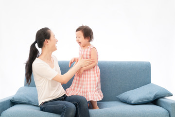 Mother and daughter are playing games on the sofa