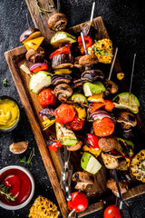 Vegan barbecue party fest concept. Whole vegetable diet kebabs set of various vegetables on skewers. Grilled vegetables on skewers - zucchini, tomato, pepper, eggplant, mushrooms, with sauces