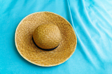 Fototapeta na wymiar .Straw hat on the blue textile background with folds
