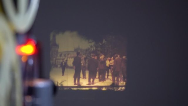 Film runs through an 8mm projector. Old projector shows a movie with an old Prague 60s