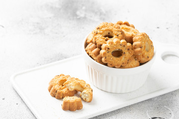 Shortbread in a white ceramic plate on a light table. A plate of cookies on the gray kitchen table